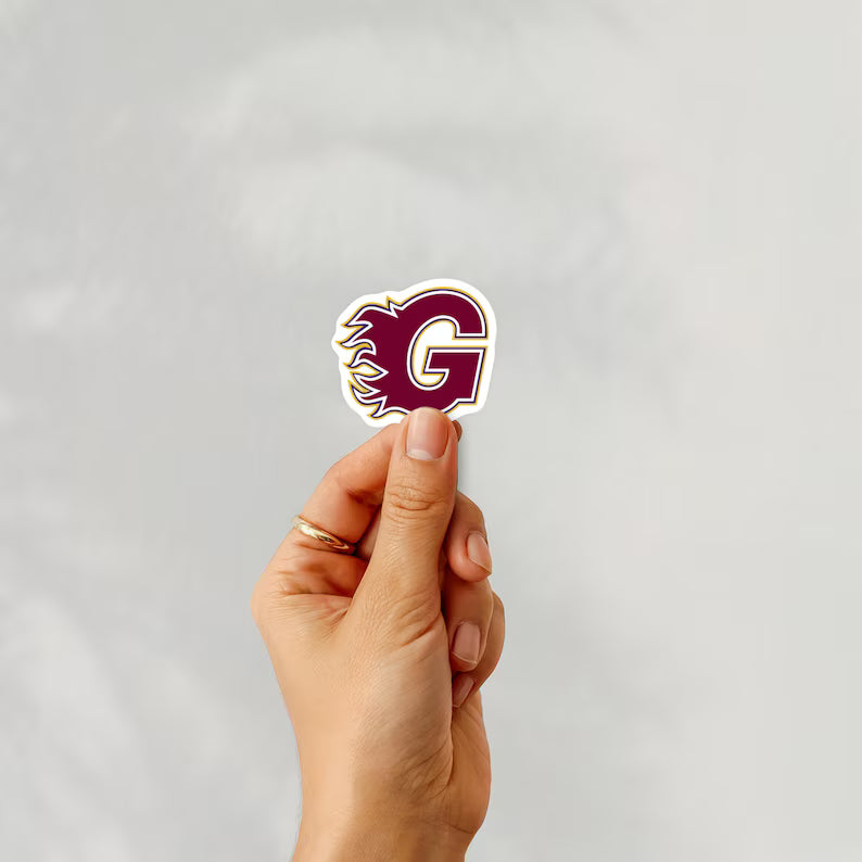 Holding a sticker of guildford flames ice hockey team logo on a white background