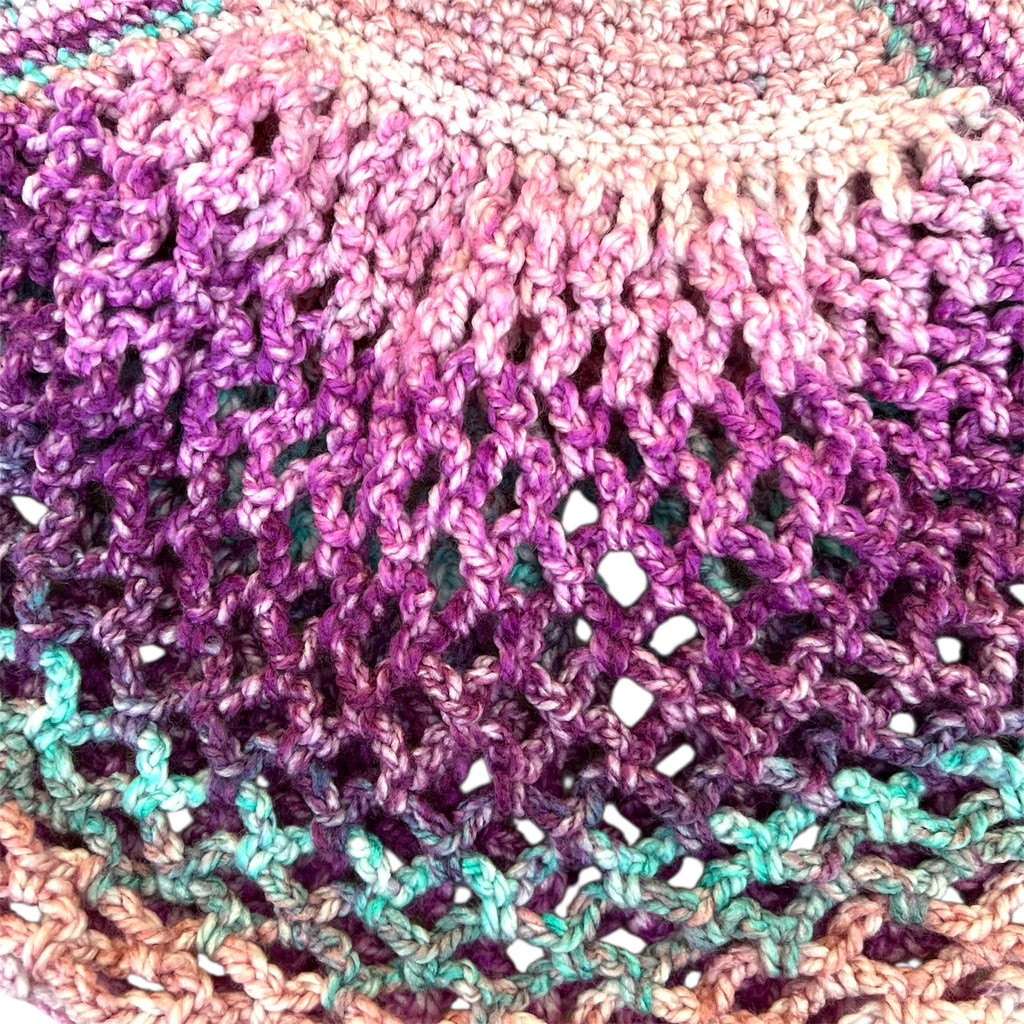 Close up picture of a pink and purple handmade crochet mesh market bag 