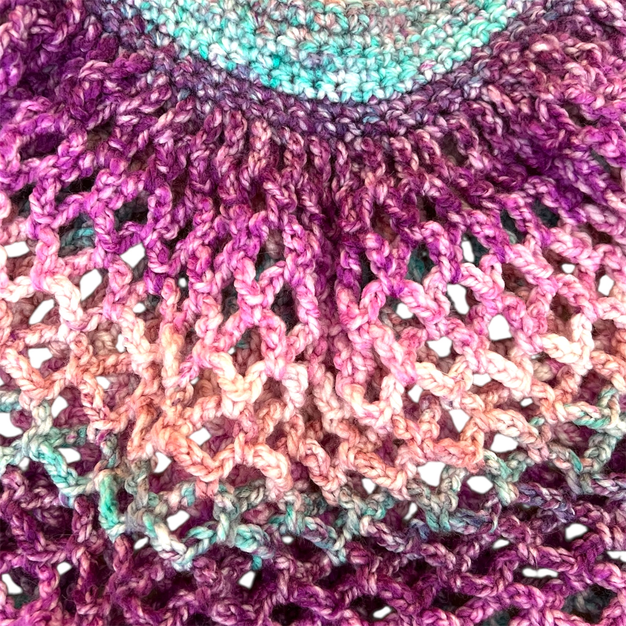 Close up picture of a pink and purple handmade crochet mesh market bag 