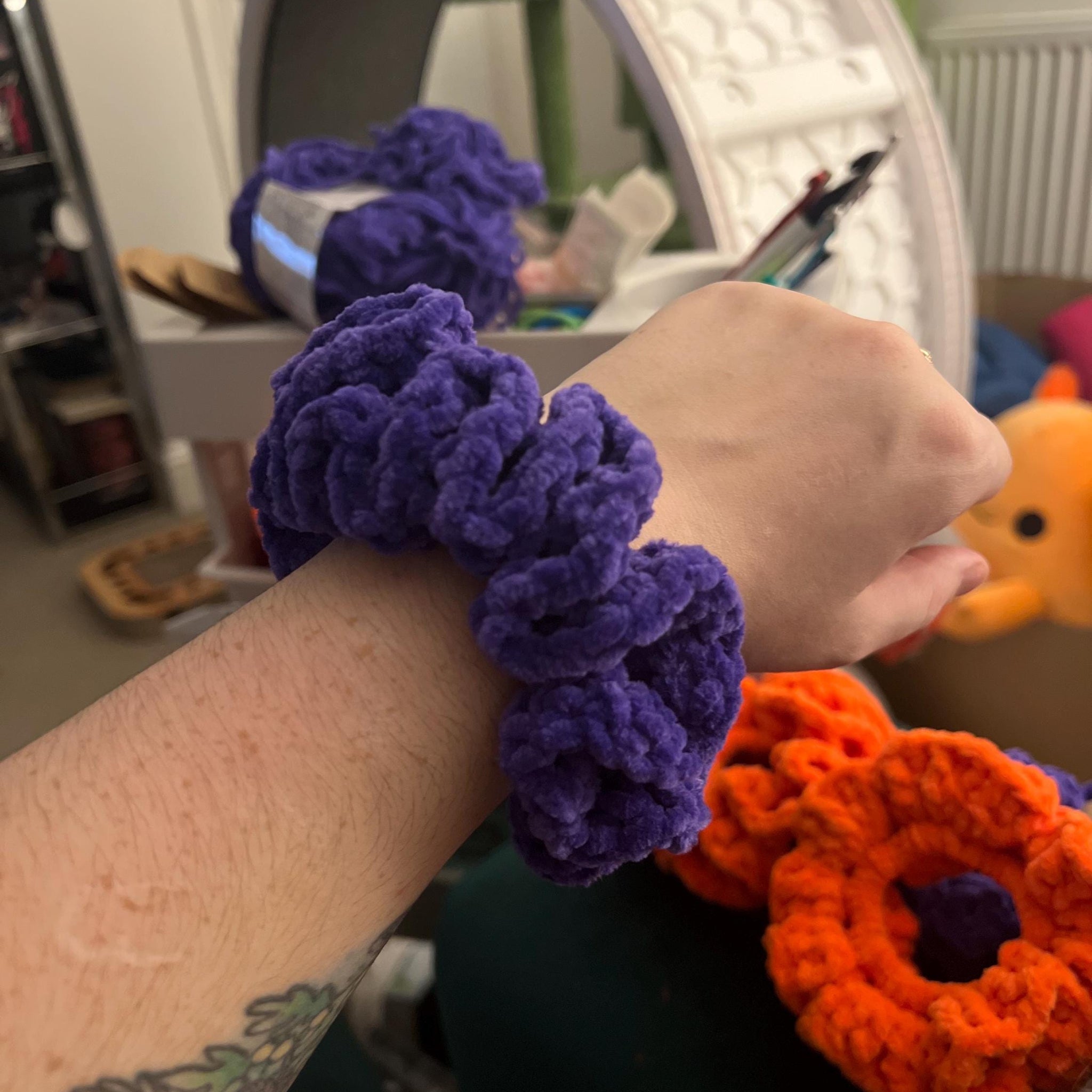 Purple manchester storm themed handmade crochet scrunhie around a wrist