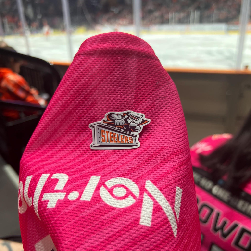 Holding a physical sticker of sheffield steelers ice hockey team logo at an ice hockey game