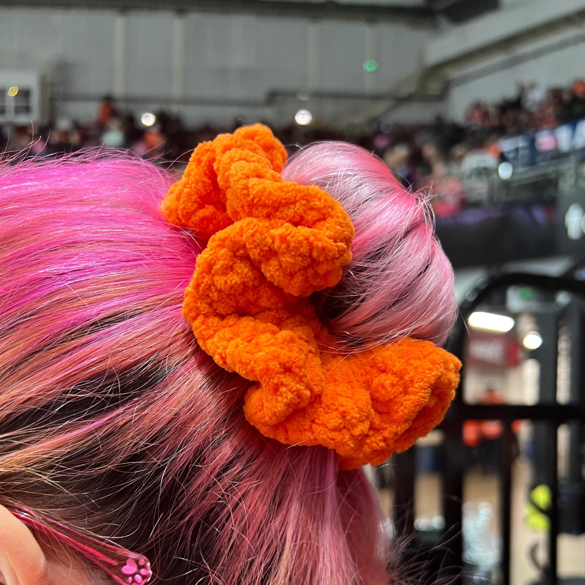 Person turned to the side showing an orange sheffield steelers themed colour srunchie